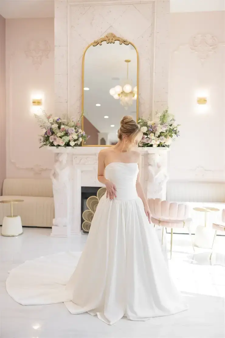 model is wearing a strapless ball gown wedding dress