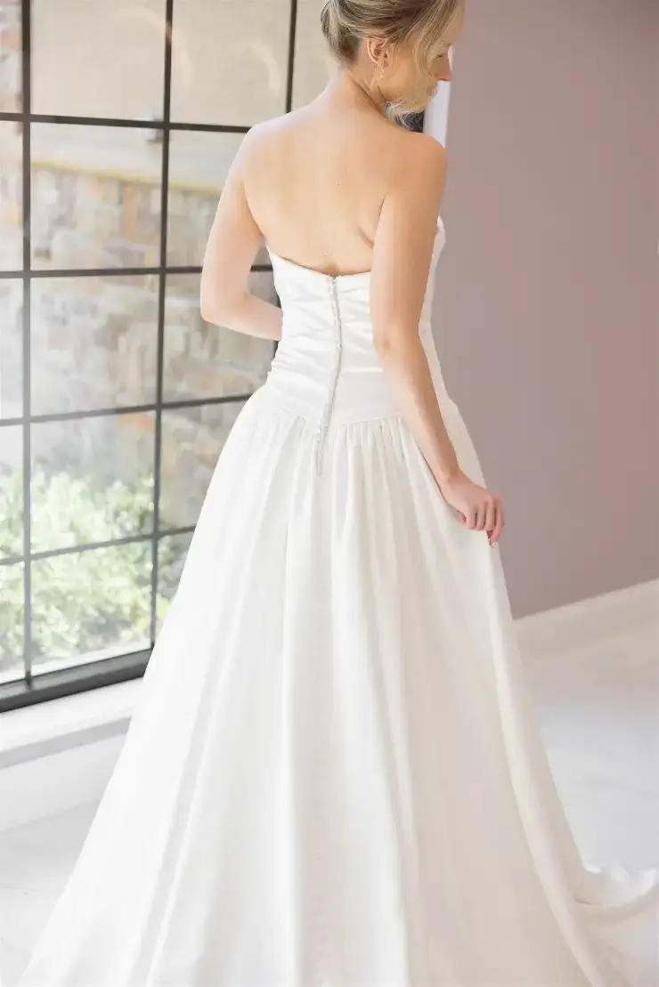 model is wearing a strapless ball gown wedding dress