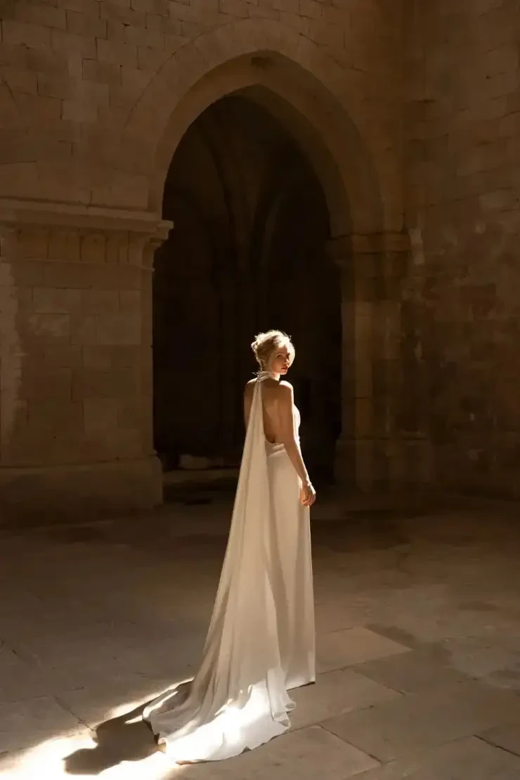 Model wearing a sheath wedding dress by Eva Lendel
