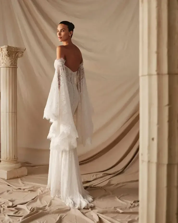 model is wearing a strapless fitted wedding dress with a corset bodice