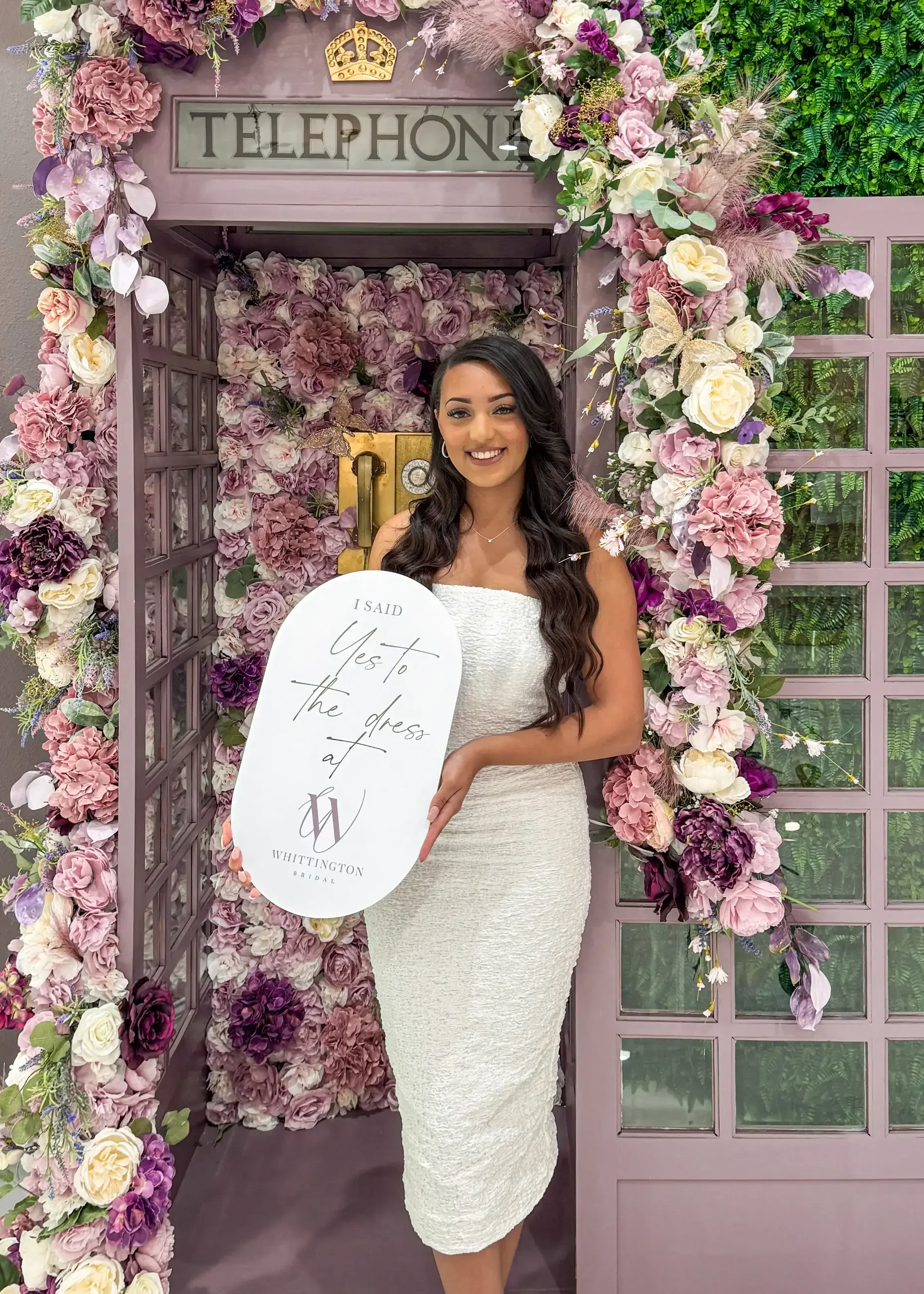 image shows a women holding a sign after finding her dream wedding dress at whittington bridal