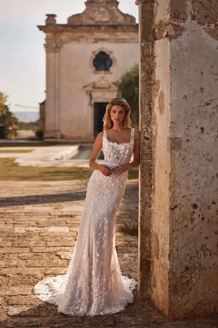 model is wearing a sleeveless fit and flare lace bridal gown