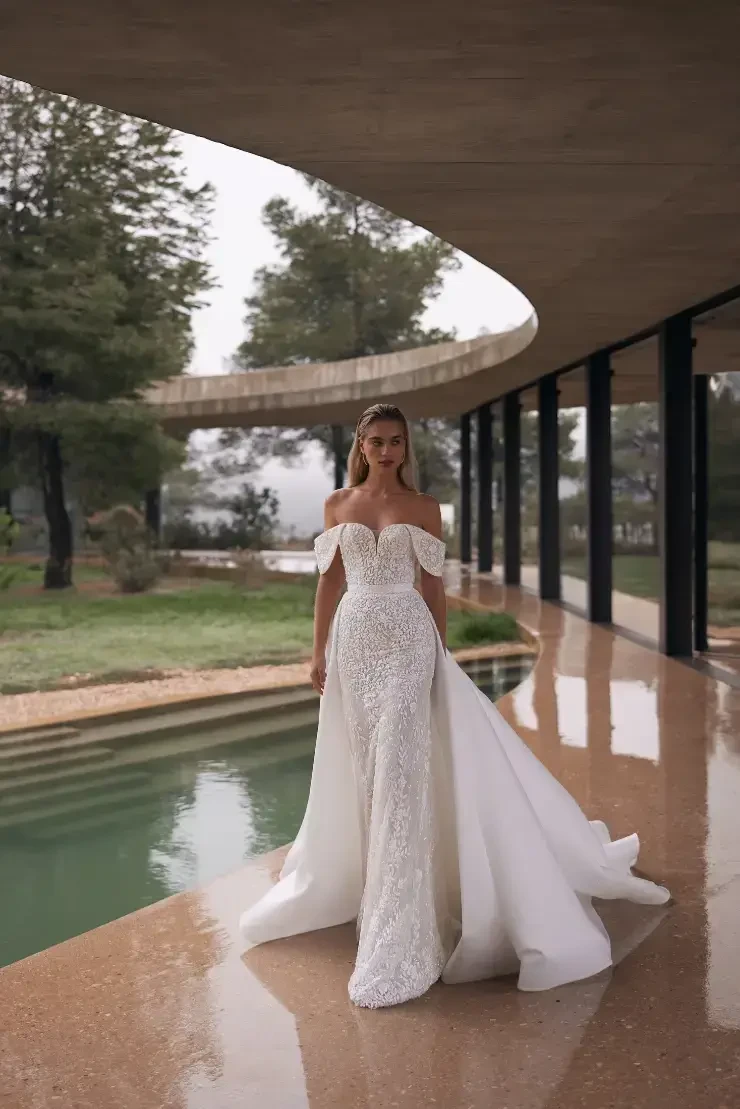model is wearing a lace off the shoulder bridal gown
