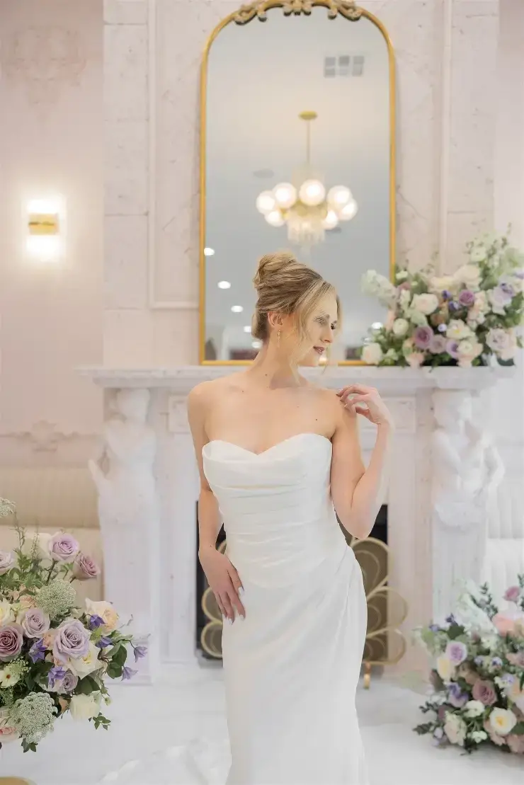 model is wearing a sleek strapless fit and flare wedding dress